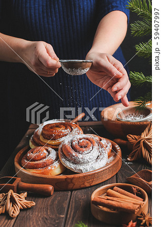 Homemade fresh cinnamon roll. Christmas cinnamon roll. pour flour or icing sugar on buns. 59407997
