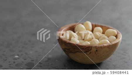 shelled macadamia nuts in olive wood bowl on terrazzo surface shelled macadamia nuts in olive wood bowl on terrazzo surface 59408441