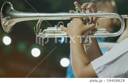 Male student with friends blow the trumpet with the band for performance on stage at night. Male student with friends blow the trumpet with the band for performance on stage at night. 59408628