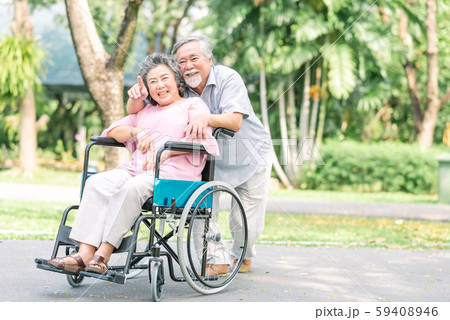 Happy senior woman in a wheelchair walking with Happy senior woman in a wheelchair walking with 59408946
