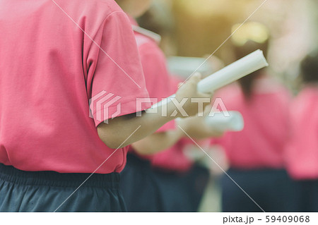 Back view of little girls use paper rolls instead of long cheerleader Baton Sticks for school parade marching practice. Back view of little girls use paper rolls instead of long cheerleader Baton Sticks for school parade marching practice. 59409068