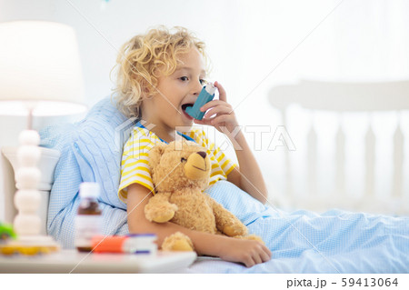 写真素材: Sick little boy with asthma medicine.