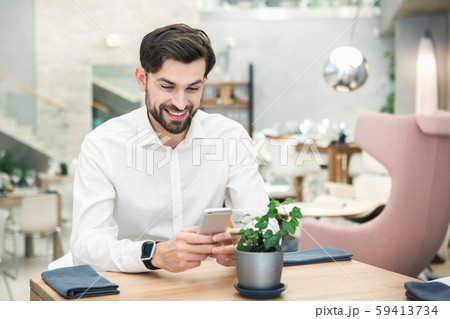 Young Man Sitting in the Restaurant Using Phone Concept 59413734