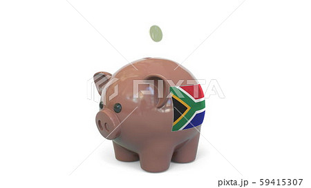 Putting money into piggy bank with flag of South Africa. Tax system system or savings related Putting money into piggy bank with flag of South Africa. Tax system system or savings related 59415307