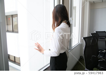家に帰りたそうに窓の外を眺める女性社員(横) 家に帰りたそうに窓の外を眺める女性社員(横) 59417963