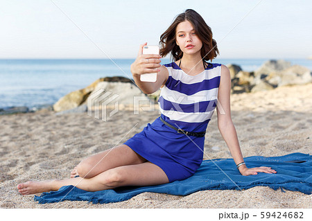Young girl resting and taking selfie 59424682