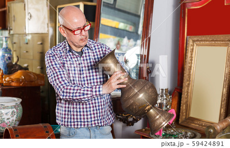 man looks at an antique vase 59424891