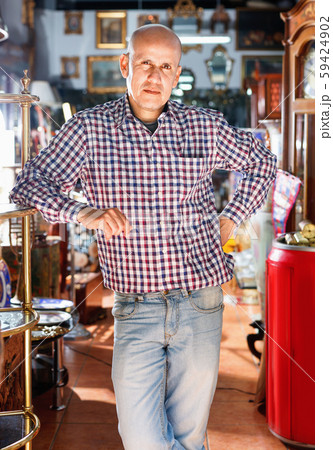 Portrait of successful owner of antiques shop among vintage things 59424902