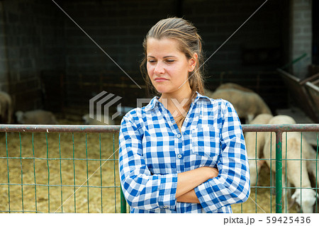 Upset woman farmer near stall of sheeps Upset woman farmer near stall of sheeps 59425436