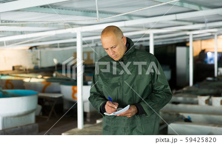 Owner of trout farm checking reservoirs with fry Owner of trout farm checking reservoirs with fry 59425820