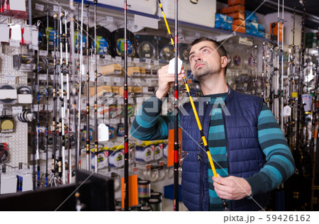 man choosing fishing rod man choosing fishing rod 59426162