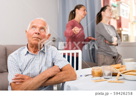 Family quarrel between the sisters. Elderly father sitting at the dinner table 59426258