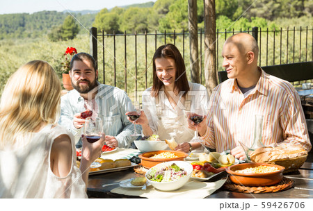 Positive middle class people enjoying food and wine on the open-air terrace 59426706
