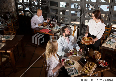 Waitress bringing dishes to guests Waitress bringing dishes to guests 59426808