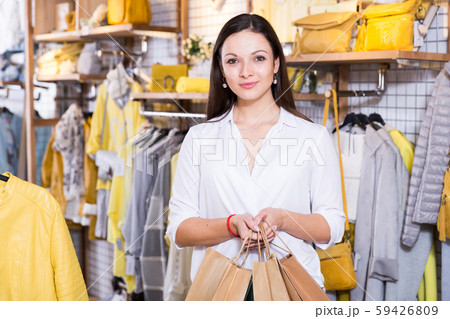Young woman customer with paper bags in clothes fashion shop 59426809