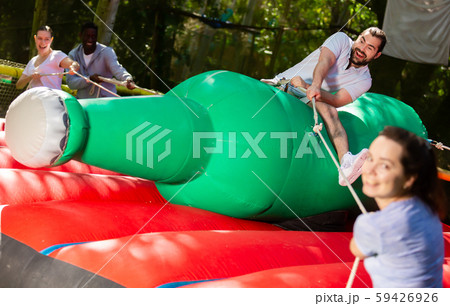Happy guy saddling inflatable rodeo bottle 59426926