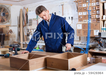 Man practising his skills with drilling machine at workshop Man practising his skills with drilling machine at workshop 59426964