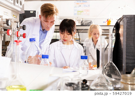 Chinese female student with male groupmate performing experiments 59427019