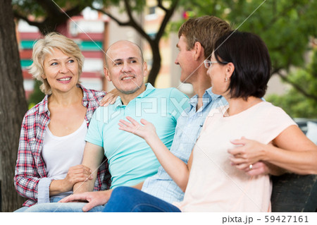 mature cheerful males and females talking outdoors 59427161