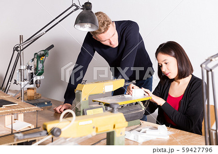 Teacher helping girl making architectural elements on scroll saw Teacher helping girl making architectural elements on scroll saw 59427796