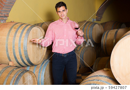 positive man posing in winery cellar 59427807