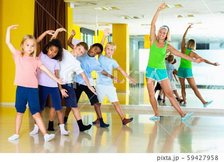 Preteen dancers practicing dance routine with female choreograph Preteen dancers practicing dance routine with female choreograph 59427958