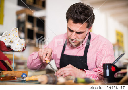 Craftsman in uniform working in carpentry Craftsman in uniform working in carpentry 59428157