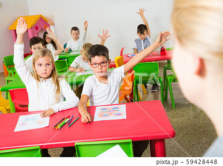 Pupils raising hands to answer Pupils raising hands to answer 59428448