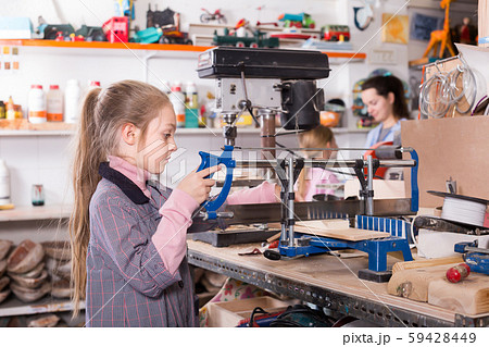 Laughing girls practicing skills at wood carving 59428449