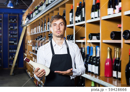 Young seller man promoting bottle of wine 59428666
