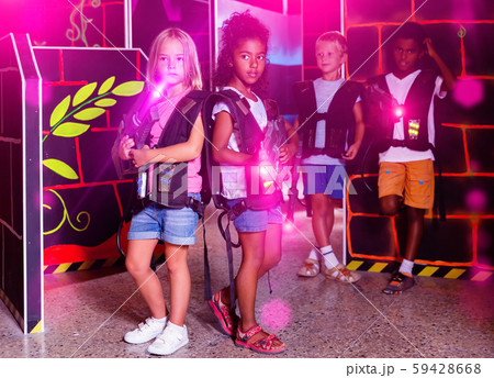 Little african and european girls standing back to back with las 59428668