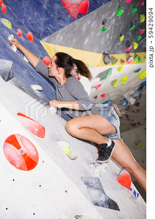 Woman climbing artificial rock in gym 59429094