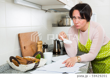 Sad housewife reading bills and crying Sad housewife reading bills and crying 59429201