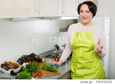 Portrait of cooking brunette housewife in apron Portrait of cooking brunette housewife in apron 59429202