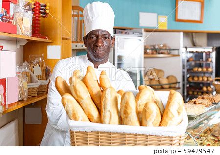 Fine African American baker holding baguettes Fine African American baker holding baguettes 59429547