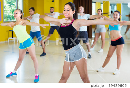 Women and men are learning zumba movements 59429606