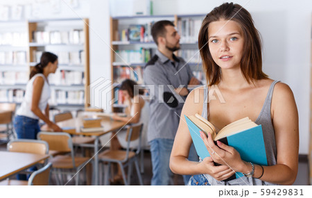 Female student browsing textbooks in library Female student browsing textbooks in library 59429831