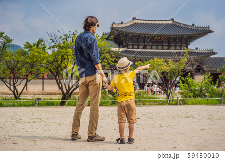 Dad and son tourists in Korea. Gyeongbokgung Palace grounds in Seoul, South Korea. Travel to Korea Dad and son tourists in Korea. Gyeongbokgung Palace grounds in Seoul, South Korea. Travel to Korea 59430010