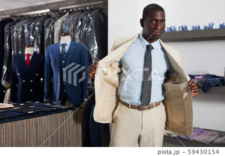 Afro-american man choosing casual jacket in fashion store 59430154