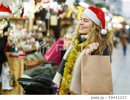 Cheerful girl near Christmas fair shops Cheerful girl near Christmas fair shops 59431227