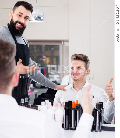 professional guy stylist demonstrating final haircut to client at hairdressing salon professional guy stylist demonstrating final haircut to client at hairdressing salon 59431307