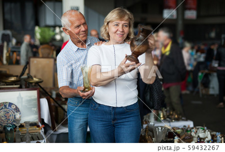 Smiling mature spouses buying retro handicrafts on flea market 59432267