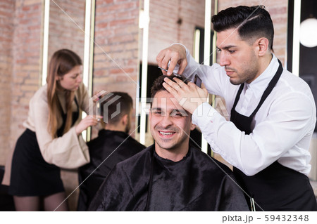 Hairdresser man doing styling of guy 59432348