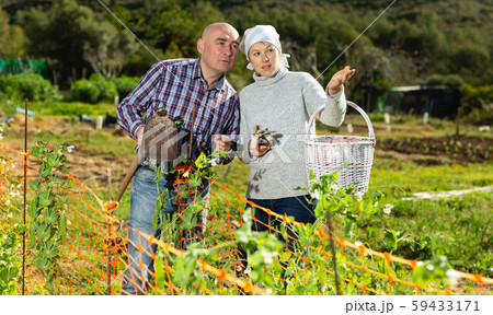 Farmer couple discussing in garden 59433171