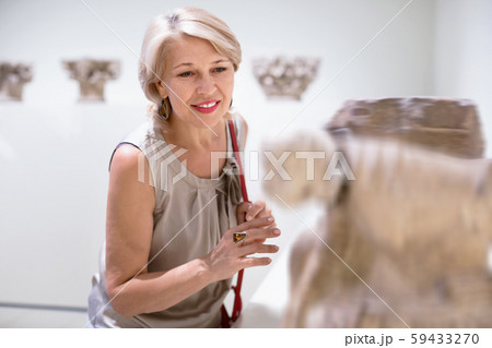 Adult female looking at artwork sculpture in the museum indoors Adult female looking at artwork sculpture in the museum indoors 59433270
