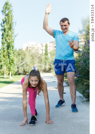 Girl standing in start position for run Girl standing in start position for run 59433514