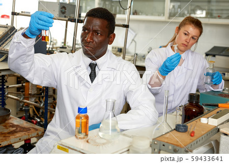 Worried lab technicians checking for result of unhappy experiment Worried lab technicians checking for result of unhappy experiment 59433641