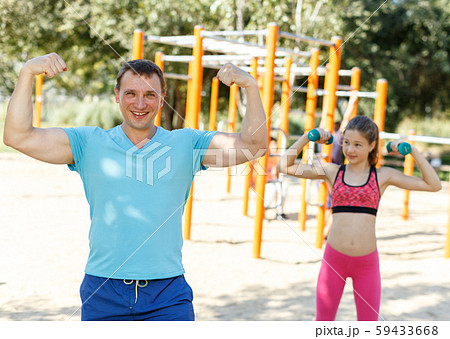 Smiling man ready for training with daughter 59433668