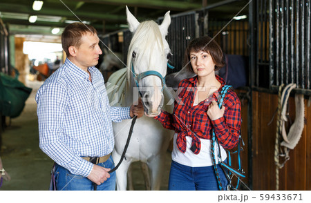Portrait of couple standing at stable Portrait of couple standing at stable 59433671