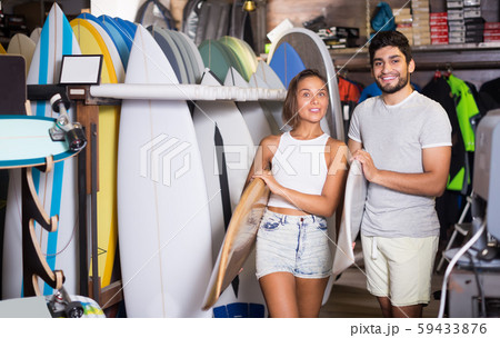 young male and female surfers holding surfboard young male and female surfers holding surfboard 59433876